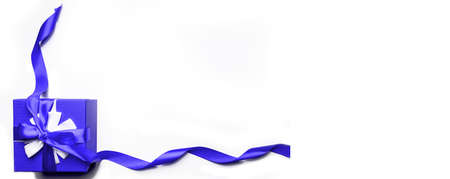Blue gift box with bow and ribbon on a white background, isolated image.Gift and holidays concept...