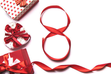 March 8 International Womens Day concept. Number 8 from red ribbon and red gift box on white...