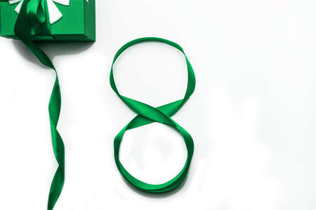 March 8 International Womens Day concept. Number 8 from green ribbon and green gift box on white background,isolated. International Womens Day concept. Flat lay,top viewの写真素材