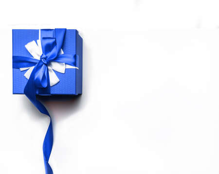 Blue gift box with bow and ribbon on a white background, isolated image.Gift and holidays concept...