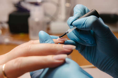 Manicurist makes hardware manicure close-up. Treatment of nails with the help of hardware manicure close-upの写真素材