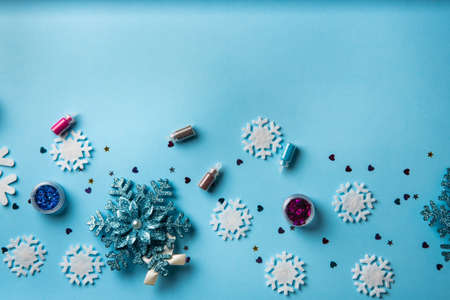 Beauty accessories for manicure and pedicure on a blue christmas background,. Samples of nail polish, scissors and other accessories for home and salon proceduresの写真素材