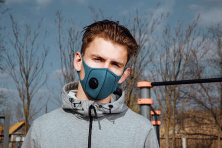 A young Man in sportswear and a protective mask on the Playground.Prevention and protection from cavid-19 and coronavirus.Healthy lifestyleの写真素材