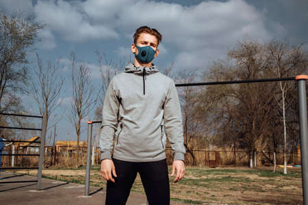 A young Man in sportswear and a protective mask on the Playground.Prevention and protection from cavid-19 and coronavirus.Healthy lifestyleの写真素材