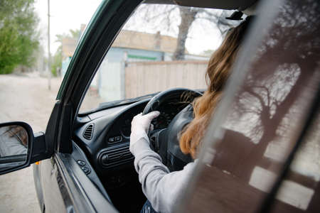 A woman driving a car in a protective mask and gloves.Prevention of coronavirus infection.Protective measures against coronavirus, covid-19の写真素材