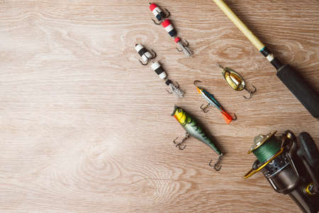 Fishing tackle-fishing spinning, lures on a wooden background..A fishing background. Fishing concept, top viewの写真素材