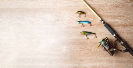 Fishing tackle-fishing spinning, lures on a wooden background..A fishing background. Fishing concept, top viewの写真素材