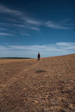 Runner athlete running in desert. Fit man training cardio outdoors. Summer sport fitness run in desert landscape.の写真素材