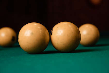 Yellow billiard balls on a green billiard table close up