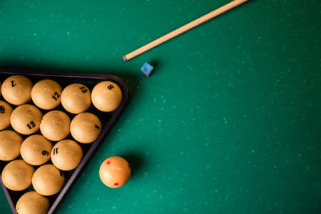 Billiard balls and cue on the billiard table, top view, flat lay.Top view billiard cue and pyramid...