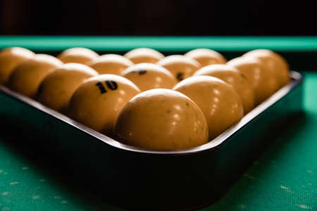 pyramid of billiard balls on the billiard table close up. Billiard balls pool in triangle on green tableの写真素材