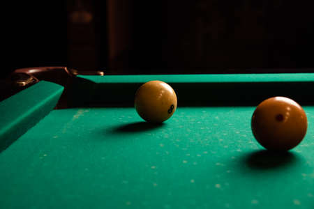 Yellow billiard balls on a green billiard table close up