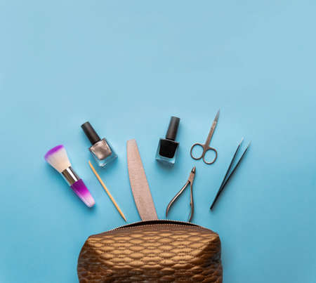 Beauty accessories for manicure and pedicure on a blue background,. Samples of nail polish, scissors...
