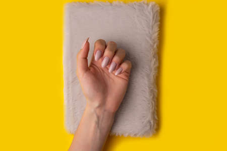 Female hands with a beautiful manicure on a yellow background,top view,flat lay. Manicure concept