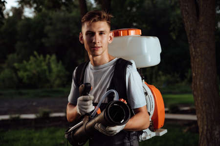 Man spraying insect repellent. Gardener with insect sprayer Use chemicals in agriculture....