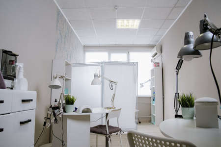 Beauty salon interior, no people. Manicure workplaces with professional tools. Interior of empty modern nail salon. Workplaces for masters of manicureの写真素材