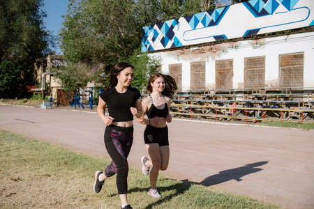 athletic girls are running, athletic girls are running at stadium.Young women running during sunny...