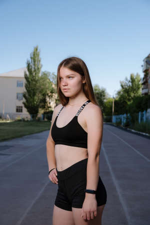 Portrait of attractive sport woman in sportswear posing outdoors at the stadium.young woman dressed in sportswear posing at the stadium on running track. Sport and healthy lifestyle.の写真素材