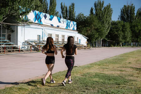 athletic girls are running, athletic girls are running at stadium.Young women running during sunny...