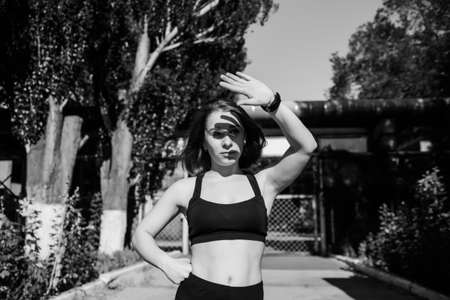 Portrait of attractive sport woman in sportswear posing outdoors at the stadium.Sport and healthy lifestyle.Black and white photoの写真素材