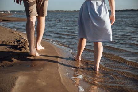 Couple in love on the beach.Happy young couple on beach. Young man and woman walking on seashore and laughing.の写真素材
