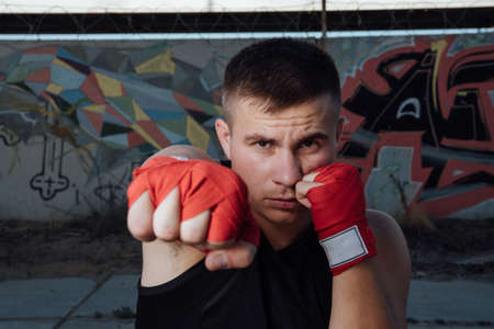 Close-up of hand of boxer ready for a fight.Strong arms and clenched fists.Hands in red boxing bandagesの写真素材