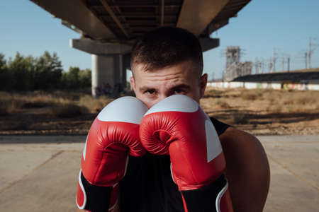 Man in red boxing gloves.Man boxer training in boxing gloves.Strength, attack and motion concept.Sporty man during boxingの写真素材