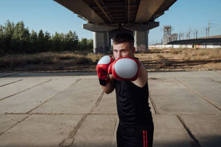 Man in red boxing gloves.Man boxer training in boxing gloves.Strength, attack and motion...
