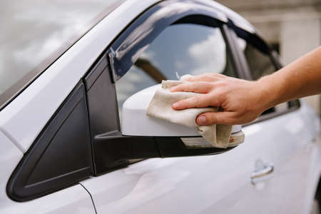 A man cleaning car with microfiber cloth, car detailing concept. Selective focus.Man polishing...