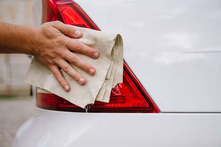 A man cleaning car with microfiber cloth, car detailing concept. Selective focus.Man polishing cleaning car with microfiber clothの写真素材