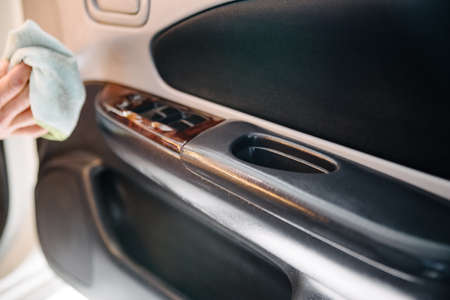 A man cleaning car with microfiber cloth, car detailing concept. Selective focus.Man polishing...