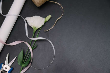 Florist equipment with flowers on wooden background, top view. Florist workplace: flowers and accessoriesの写真素材