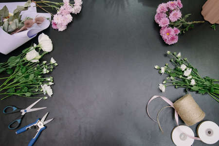 Florist equipment with flowers on wooden background, top view. Florist workplace: flowers and accessoriesの写真素材