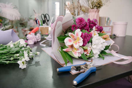 Florist equipment with flowers on wooden background. Florist workplace: flowers and accessoriesの写真素材