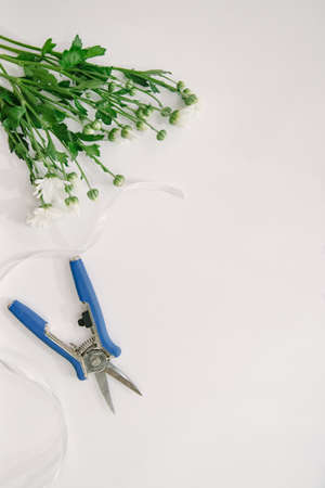 Florist equipment with flowers on wooden background, top view. Florist workplace: flowers and accessoriesの写真素材