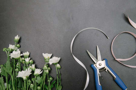 Florist equipment with flowers on wooden background, top view. Florist workplace: flowers and accessoriesの写真素材