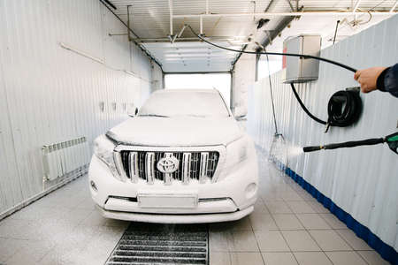 Car wash with soap.Car getting a wash with soap, car washing.Soaping with foam on car in self-service car wash.のeditorial素材