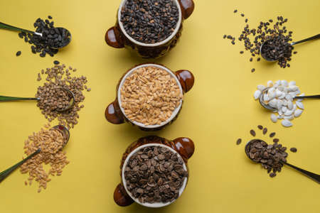 Watermelon, pumpkin and melon seeds on a yellow background. Different types of seeds, top view....