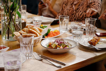 Wooden Table with food and drinks.People talk and eat together during a table meetingの写真素材