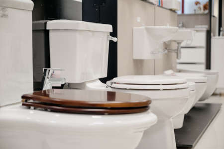 Row of modern new white toilet bowls in a plumbing store.New white toilets close-upの写真素材
