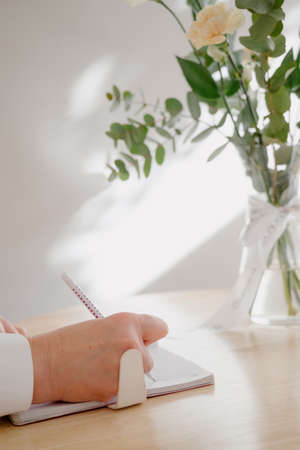 A woman's writing hand.A woman writes in a notebook close-up.A woman's hand writes with a ballpoint...