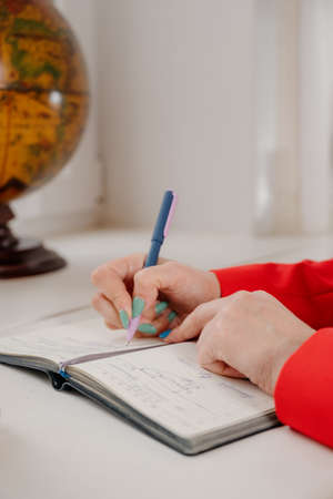 A woman's writing hand.A woman writes in a notebook close-up.A woman's hand writes with a ballpoint...
