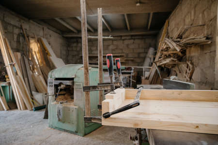 Clamped pieces of wood with c-clamps and bar clamp , wooden parts in the carpentry workshop.Clamps in the workshop.の写真素材