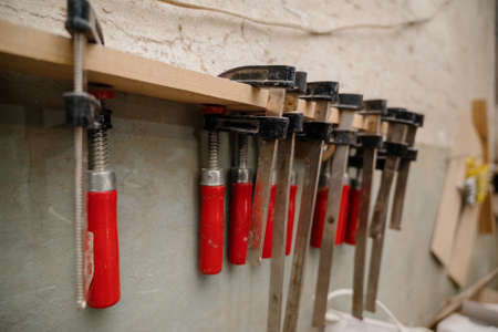 Clamped pieces of wood with c-clamps and bar clamp , wooden parts in the carpentry workshop.Clamps...