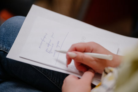 A woman's writing hand.A woman writes in a notebook close-up.A woman's hand writes with a ballpoint pen close-upの写真素材