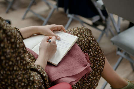 A woman's writing hand.A woman writes in a notebook close-up.A woman's hand writes with a ballpoint...