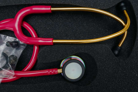 medical stethoscope. Red medical stethoscope.The concept of healthcare.Stethoscope on a dark backgroundの写真素材