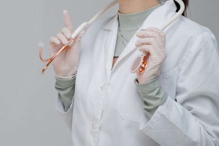 White medical stethoscope.A doctor with a stethoscope.A doctor holding a stethoscope.The concept of healthcare.の写真素材