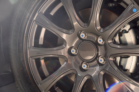 Car wheel with brake calipers and stylish design. Cast disk close up with calipers and brake pads