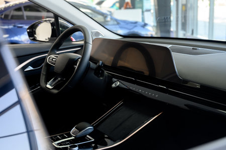 Black leather steering wheel, automatic transmission and modern control display in a modern car. Close-up of a modern new car interior.の写真素材